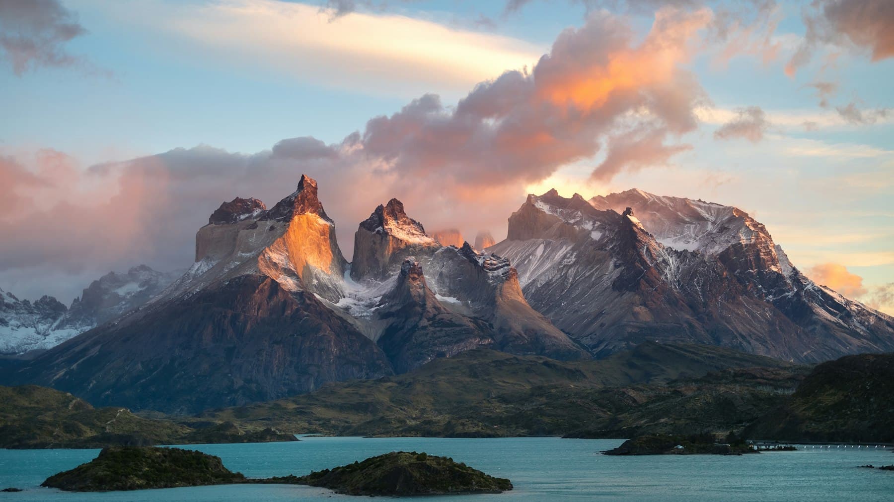 Macizo montañoso de la Patagonia al atardecer frente a un lago